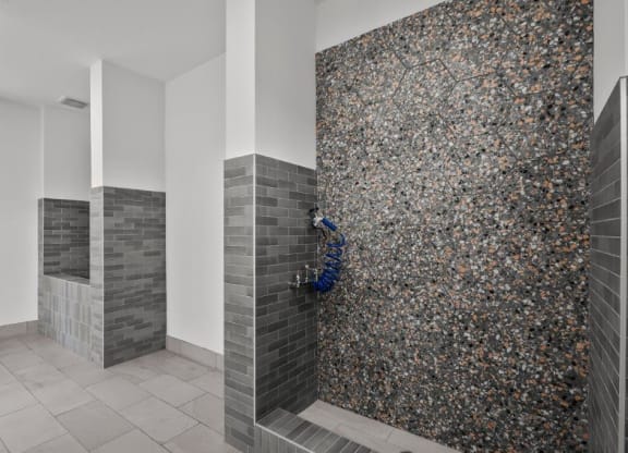 a bathroom with a shower with a blue hose in it