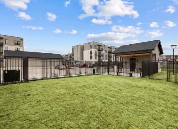 a fenced in yard with apartments in the background