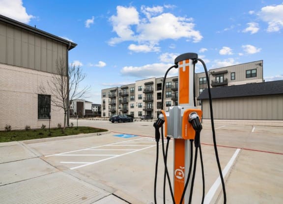 an orange gas pump in a parking lot next to a building