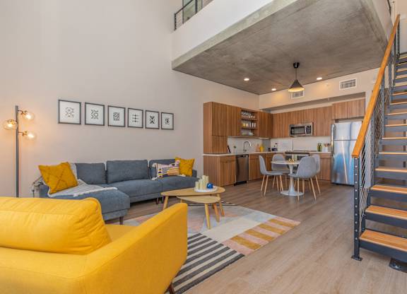 A living room with a yellow sofa and a grey couch.