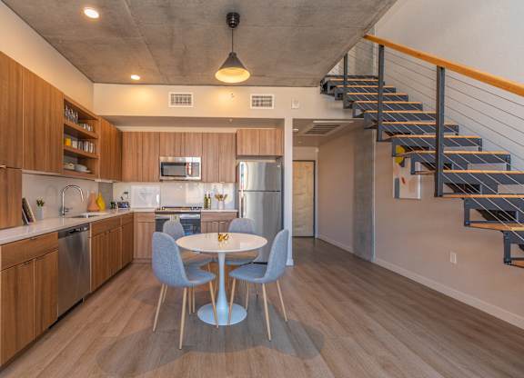 A kitchen with a table and chairs in the middle of the room.