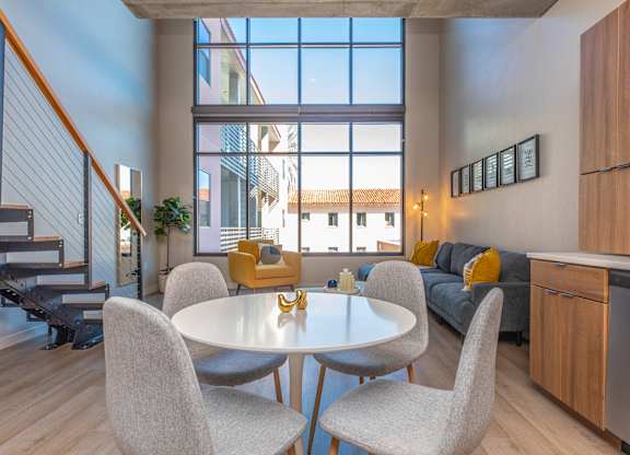 A modern dining room with a glass table and chairs.