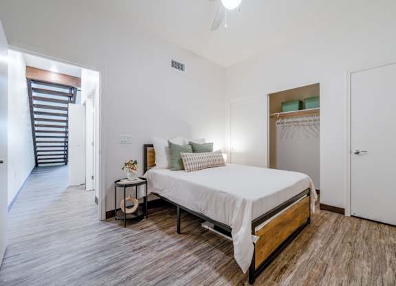 A bedroom with a bed, nightstand, and a ceiling fan.