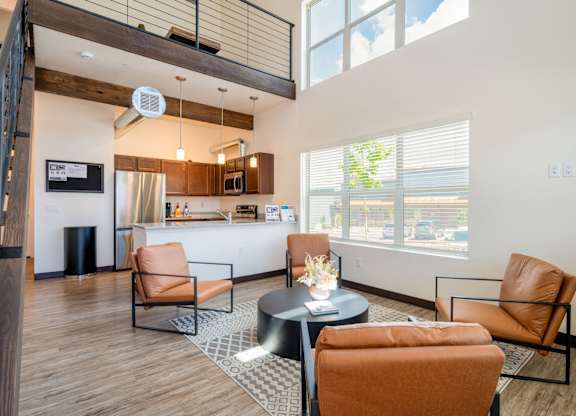 A living room with a black coffee table and orange chairs.