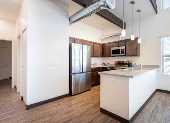 A modern kitchen with a white island and stainless steel appliances.