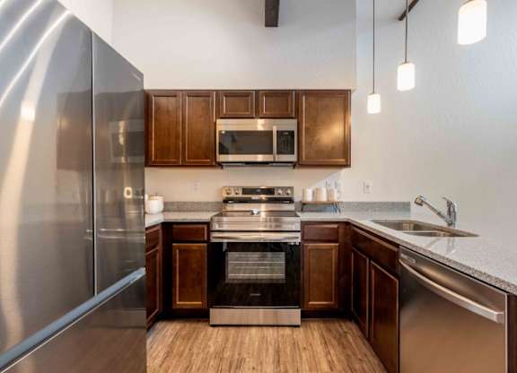 A modern kitchen with wooden cabinets and stainless steel appliances.