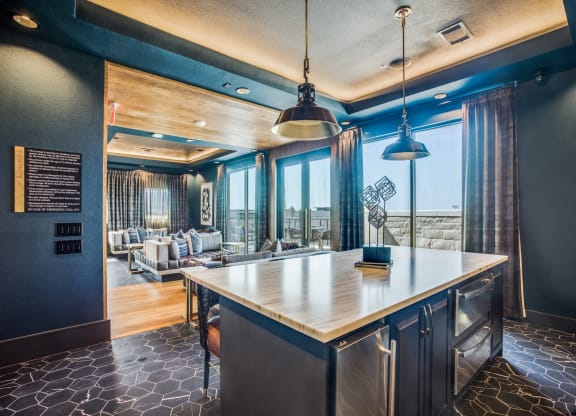 a kitchen with a large island and a living room in the background