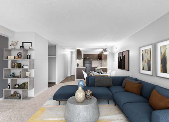 A modern living room with a grey sofa and a yellow rug.