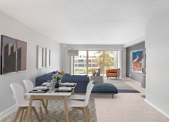 A dining room with a table set for two and a couch.