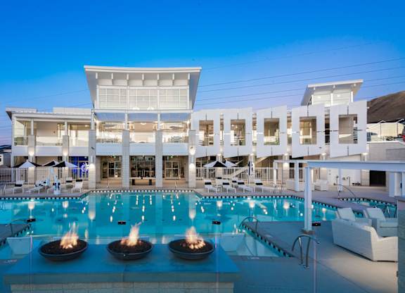 A large white building with a pool in front of it.
