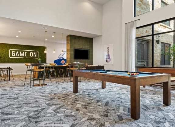 a game room with a pool table and a bar