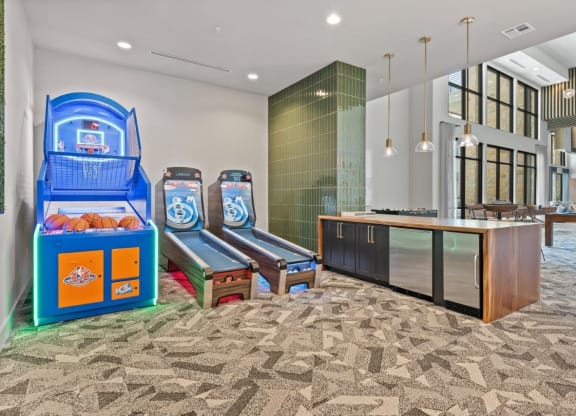 the lobby or reception area of a hotel with game machines and benches