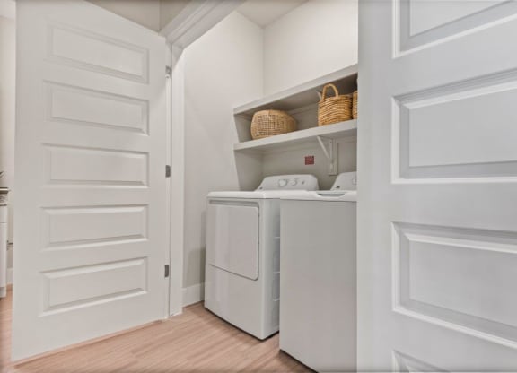 a laundry room with a washer and dryer and a white door