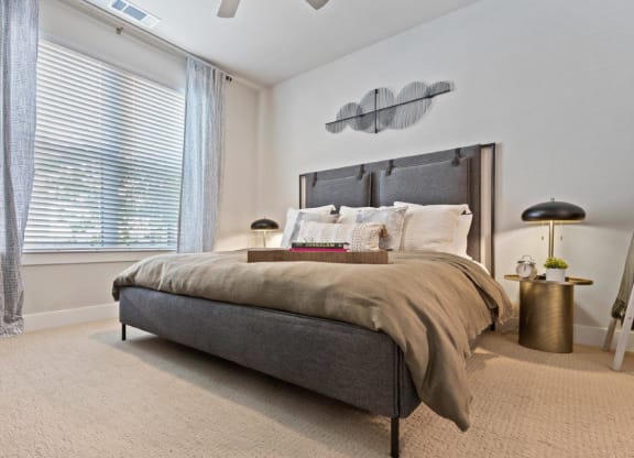a bedroom with a bed and a large window