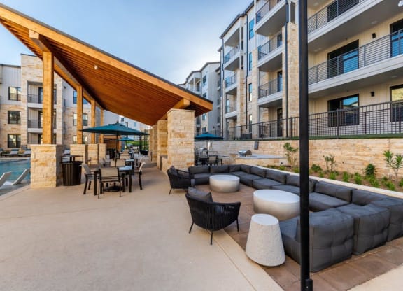 a patio with couches tables and chairs and a pool