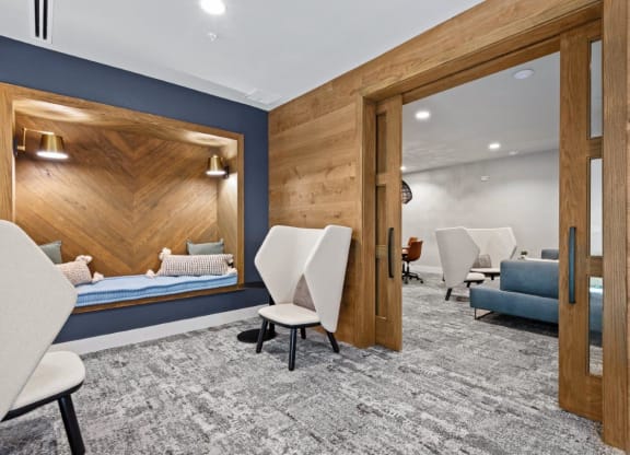a patient room with a bed and chairs and a mirror