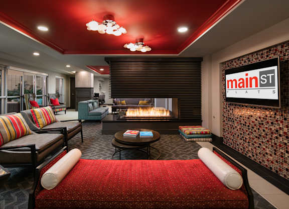 A living room with a red couch and a fireplace.
