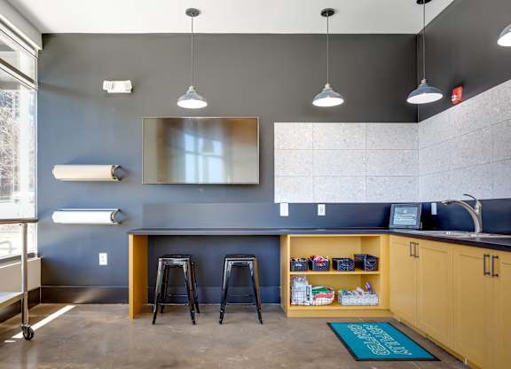 a kitchenette with a bar and stools