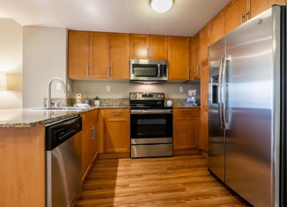 The Mercer kitchen area with fridge, sink, and appliances