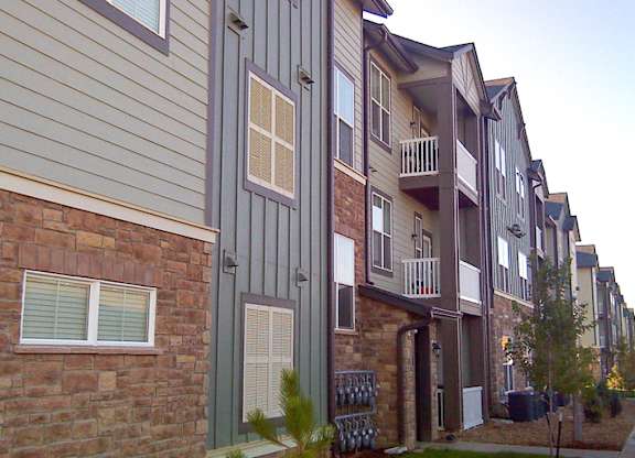 A row of townhouses with balconies and doors.