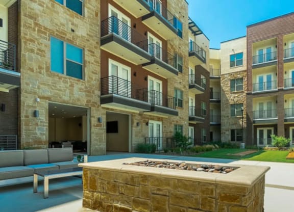 A stone bench in front of apartment buildings.