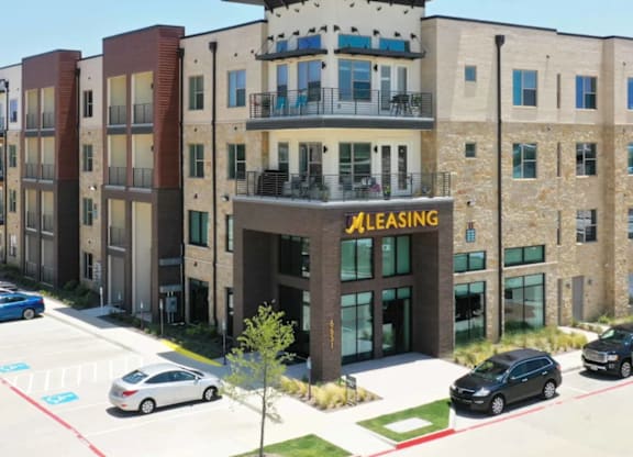 A multi-story building with a leasing office in front.