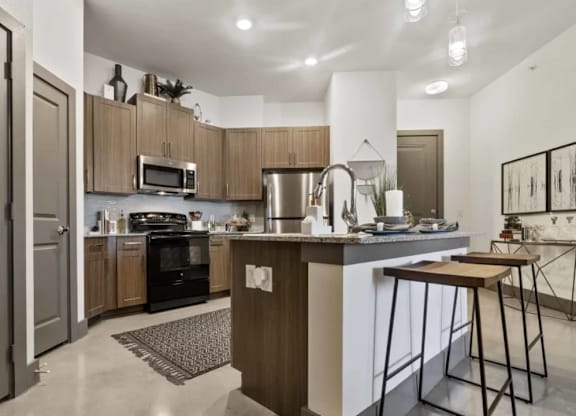 A modern kitchen with a white countertop and wooden cabinets.