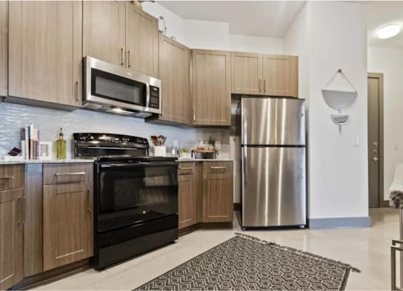 A kitchen with wooden cabinets and a black oven.