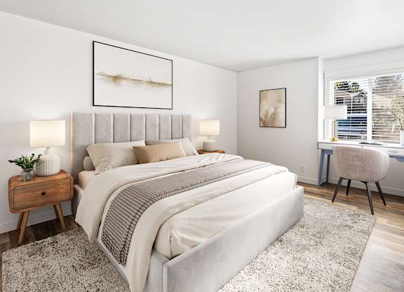 A bedroom with a large bed, a desk with a chair, and a window with blinds.