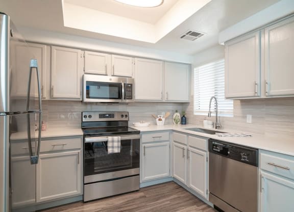 a kitchen with white cabinets and stainless steel appliances
