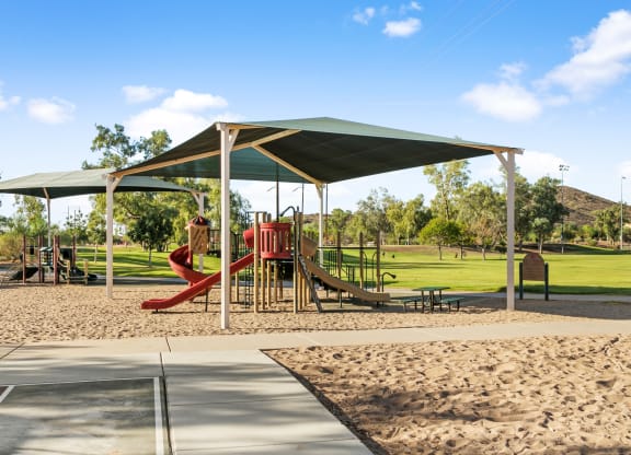 a playground with a swing set and sand