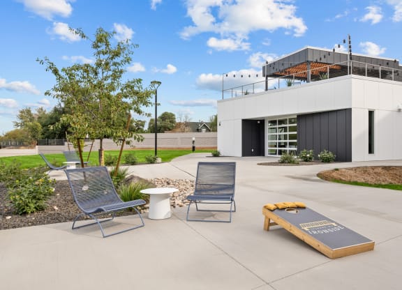 a patio with two chairs and a coffee table in front of a building
