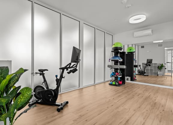 a home gym with white walls and a wood floor