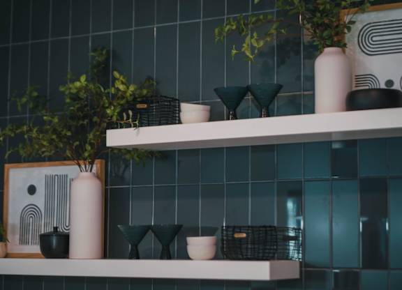 A shelf with various decorative items including vases and a plant.