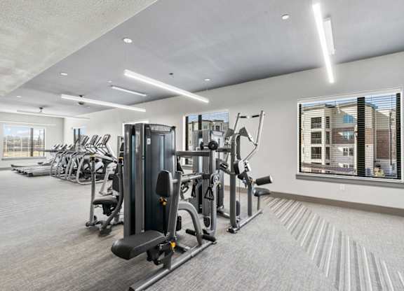 A well-lit gym with a variety of equipment.