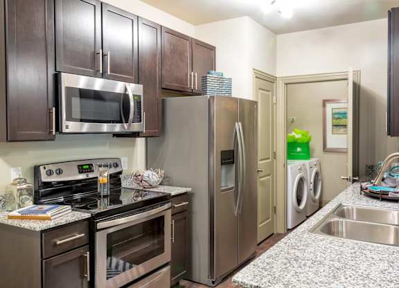 A kitchen with a stove top oven, microwave, and refrigerator.
