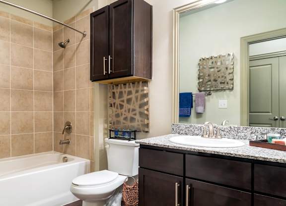 A bathroom with a white toilet, a white sink, and a white bathtub.