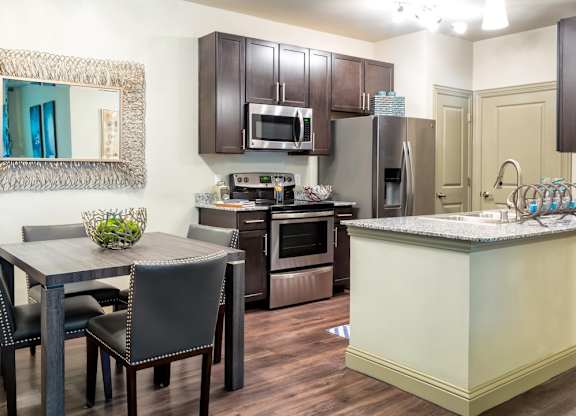 A kitchen with a table and chairs.