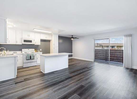A spacious kitchen with white appliances and a large island.