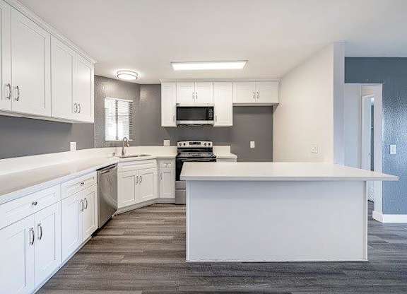 A modern kitchen with white cabinets and a large island.
