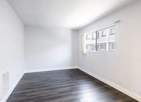A room with a window and a radiator on the wall.