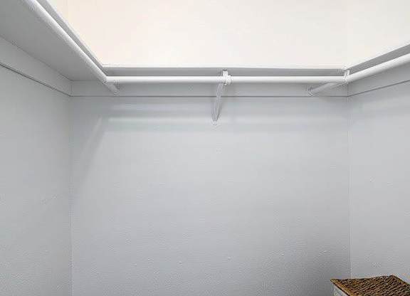 A white wall with a white pipe and a brown table.