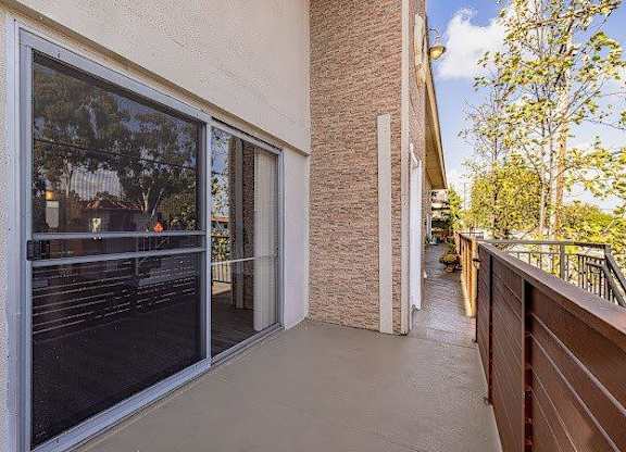 A balcony with a glass door and a railing.