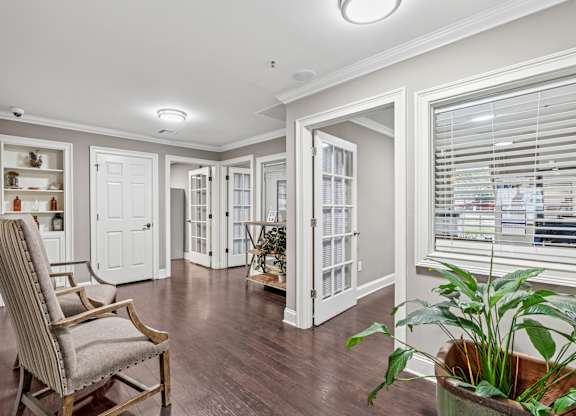 A room with a chair and a potted plant.