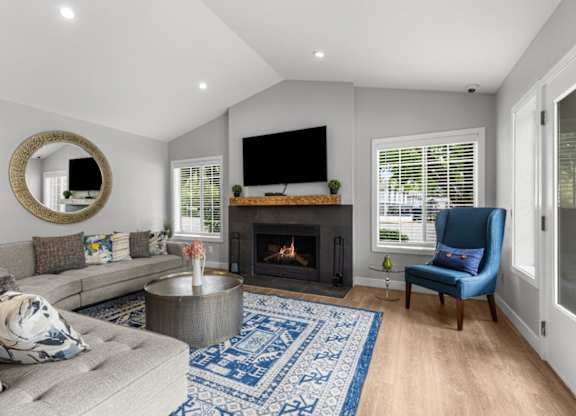 a living room with a couch and a chair and a fireplace