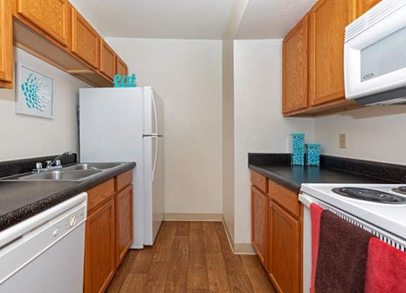 A kitchen with wooden cabinets and a white fridge.