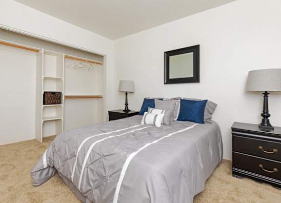 A bedroom with a bed, dresser, and a mirror on the wall.
