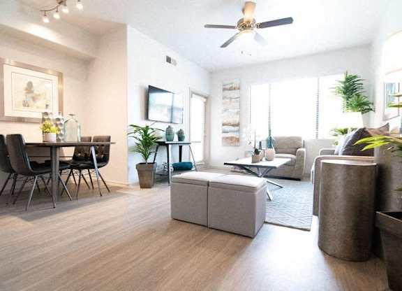 a living room and dining room with a ceiling fan