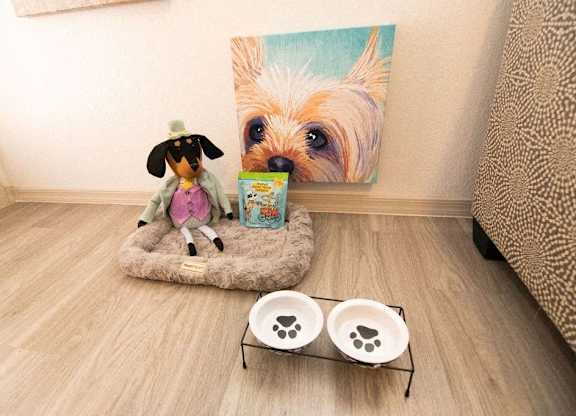 a dog sitting on a bed in front of a painting of a dog