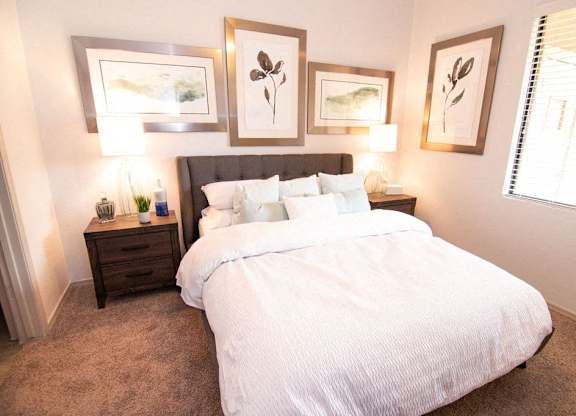a bedroom with a bed and pictures on the wall